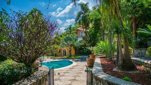 A stone pathway leading to a pool surrounded by lush greenery and a building with a tiled roof. - Anana Rancho San Rafael Master BD Lake Views (Chapala)