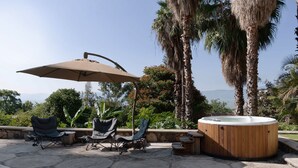 An outdoor patio with two lounge chairs, a large umbrella, and a hot tub. - Anana Rancho San Rafael Villa With Pool Views (Chapala)
