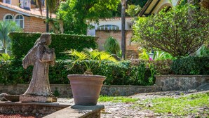 A garden with a statue, a potted plant, and a stone wall. - Anana Rancho San Rafael Villa With Pool Views (Chapala)