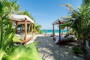 Ein Strandresort mit Holzbauten, einem Sandstrand und freiem Blick auf den Ozean.