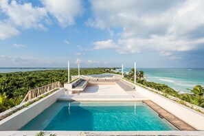 Una piscina con vistas al océano y un paisaje tropical.