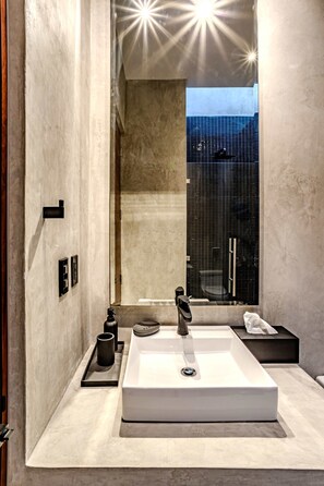 A modern bathroom with a large white sink, a glass shower enclosure, and a view of the cityscape. - Anana Casa Karmond Luxury Villa With Pool (Tulum)
