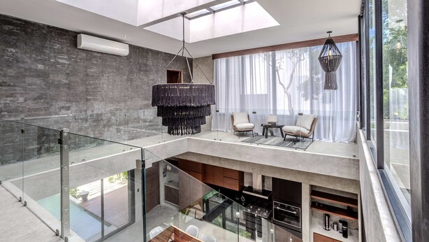 A modern interior with a glass railing, a hanging light fixture, and a view of the outdoors. - Anana Casa Karmond Luxury Villa With Pool (Tulum)