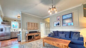 A spacious living room with a wooden coffee table, a blue sofa, and a large rug.