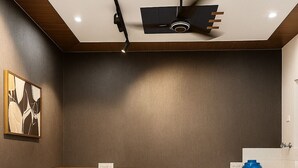 A modern living room with a black sofa, a round white coffee table, and a ceiling fan. - Let'stay- Noida (Noida)