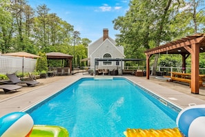 A swimming pool with lounge chairs, a gazebo, and a covered patio area. - Barnstable Cape Cod Retreat | Pool, Fire Pit & BeachSticker (Barnstable)