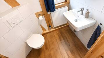 Un bagno con il water, un lavandino e una finestra.