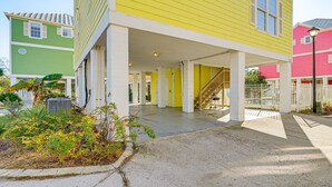Ein gelbes Gebäude mit einer Veranda und einer Treppe, die zu einer oberen Etage führt.