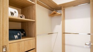 Un armario de madera con estantes, una barra para colgar ropa y una puerta con manija.