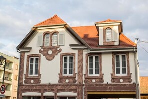 A multi-story building with a classic architectural style, featuring symmetrical windows and decorative moldings. - Les Chambres de Louise (Habsheim)