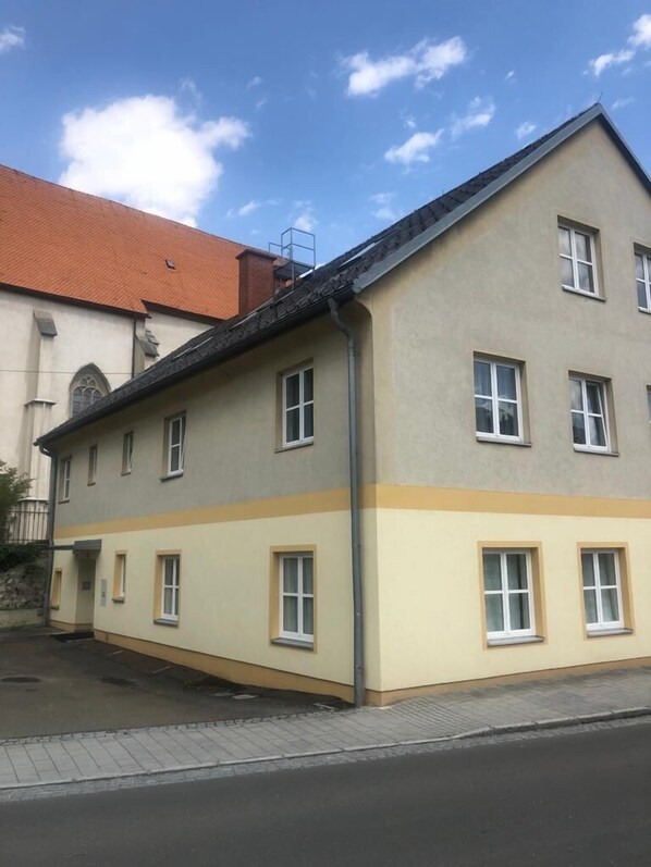Un edificio de varios pisos con techo plano y fachada color beige.