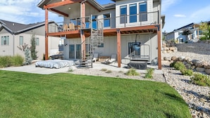 A two-story house with a covered patio, a staircase, and a deck.