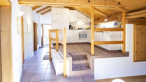 Une cuisine de taille réduite avec des meubles blancs, une cuisinière et un évier.