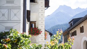 Un bâtiment à la façade géométrique, orné d’une fenêtre avec des fleurs rouges.
