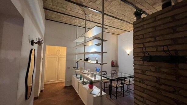 Una cocina moderna con armarios blancos, una isla central con lavamanos y una lámpara colgante.