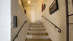 Un escalier avec des marches en pierre et des rampes en métal noir.