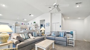 A modern living room with two sofas, a coffee table, and a kitchen in the background.