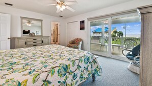 A bedroom with a bed, dresser, and a view of the outside.