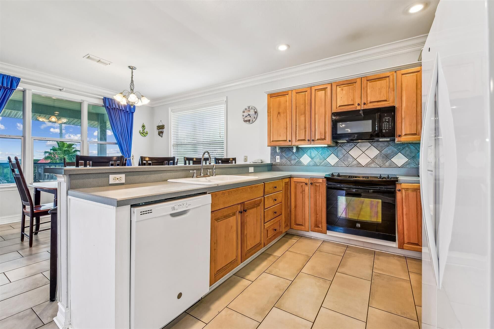 A modern kitchen with wooden cabinets, a built-in dishwasher, a microwave, and an oven.
