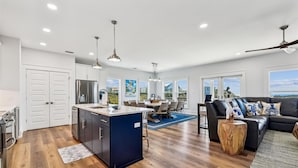 A spacious living area with a kitchen, dining space, and a view of the outdoors.