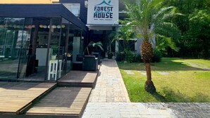 A modern building with a sign reading "Forest Beach House" indicating a nature experience. - Foresthouse Beach Hostel (Florianópolis)
