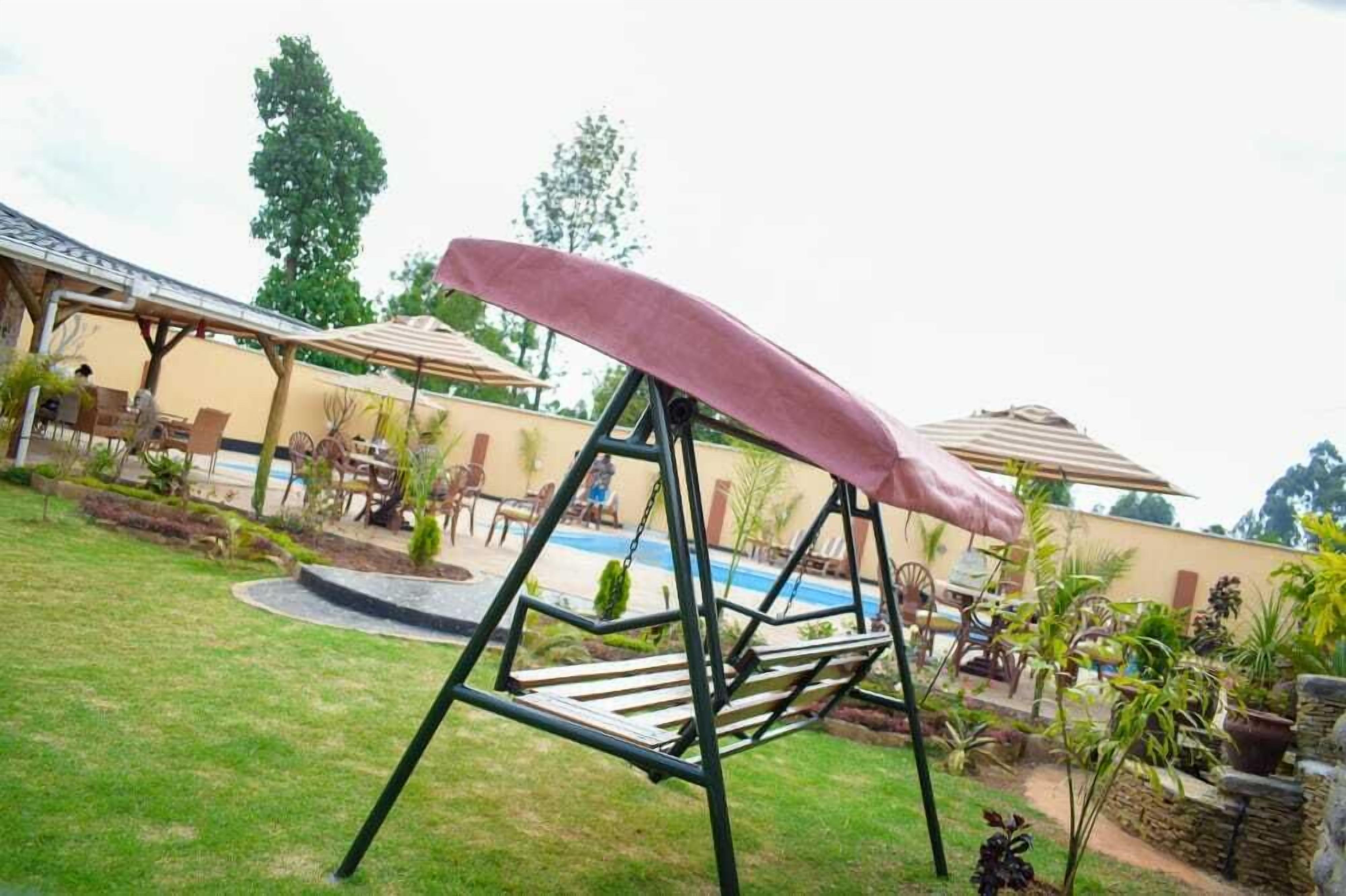 Un patio trasero con un tobogán, una piscina y mobiliario exterior.
