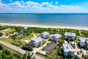 A coastal hotel with multiple buildings, a parking area, and a beach view. - Surfside 12 A4 - Stunning, 3 bedroom, 2 bathroom condo with water views! (Sanibel Island)