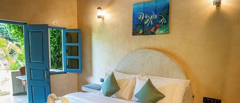 A bedroom with a bed, a nightstand, an air conditioning unit, and a painting on the wall.