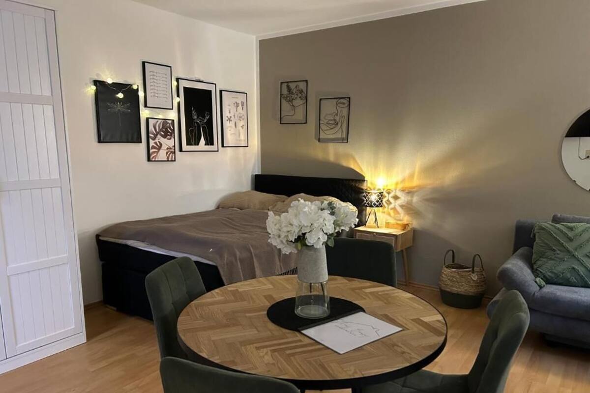 Un dormitorio con cama, mesita de noche, lámpara y decoración en la pared.