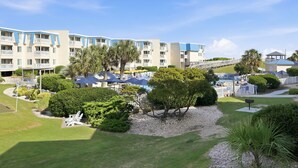 Un hotel con edificios de varios pisos, zonas de estar al aire libre y un césped bien cuidado.