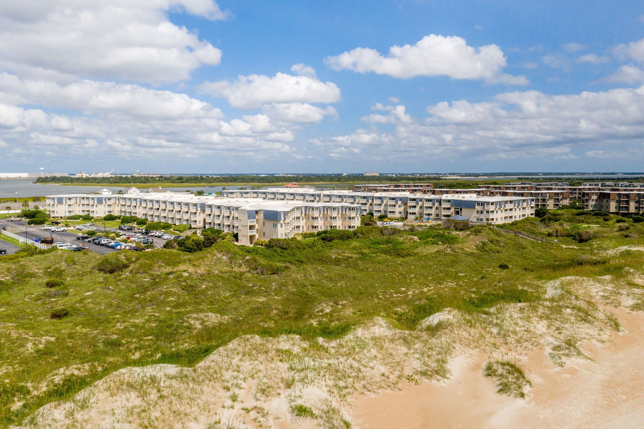 A multi-story residential building with a parking lot in front.
