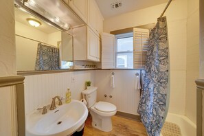 A bathroom with a sink, toilet, and shower curtain. - 4 Mi to Downtown! Cozy Bungalow in San Antonio (San Antonio)