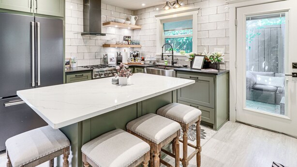 A modern kitchen with a large island, green cabinets, and a view to the outside. - Walk to Zilker Park, Barton Springs Pool! Cozy Gem (Austin)