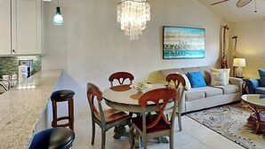Une cuisine moderne avec un coin repas, un lustre et un ventilateur de plafond.