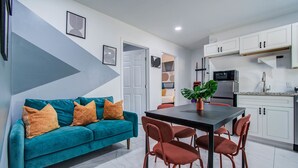 A modern kitchen with white cabinets, a black countertop, and a stainless steel refrigerator.