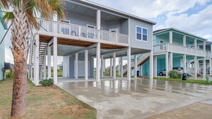 A two-story building with a covered patio area and a staircase leading to the upper level. - Home w/ Pool Access in Rockport! (Rockport)