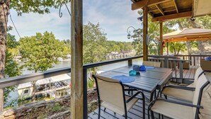 An outdoor deck with a table and chairs, overlooking a body of water and trees. - Dock + Views: Scenic Group Retreat on Grand Lake! (Eucha)