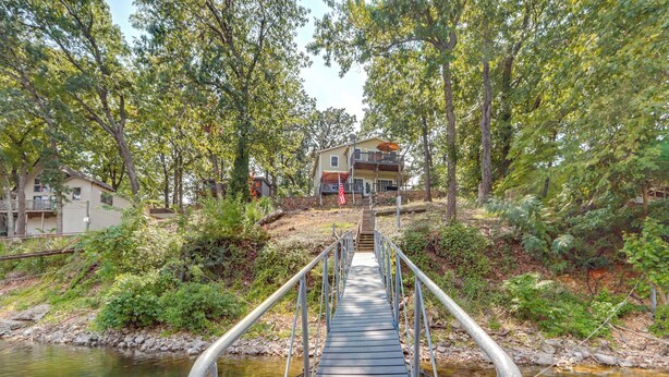 A wooden bridge leading to a house surrounded by trees. - Dock + Views: Scenic Group Retreat on Grand Lake! (Eucha)