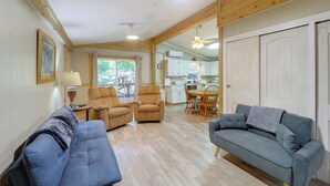 A spacious living area with two sofas, a dining table, and a kitchen in the background. - Community Perks! Mountain Home w/ Deck in Newland (Newland)