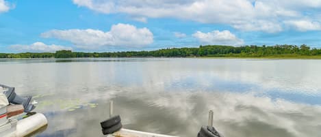 A wooden dock extending into calm water with a clear sky above.