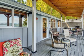 Un patio extérieur couvert, aménagé avec des sièges et un espace barbecue.