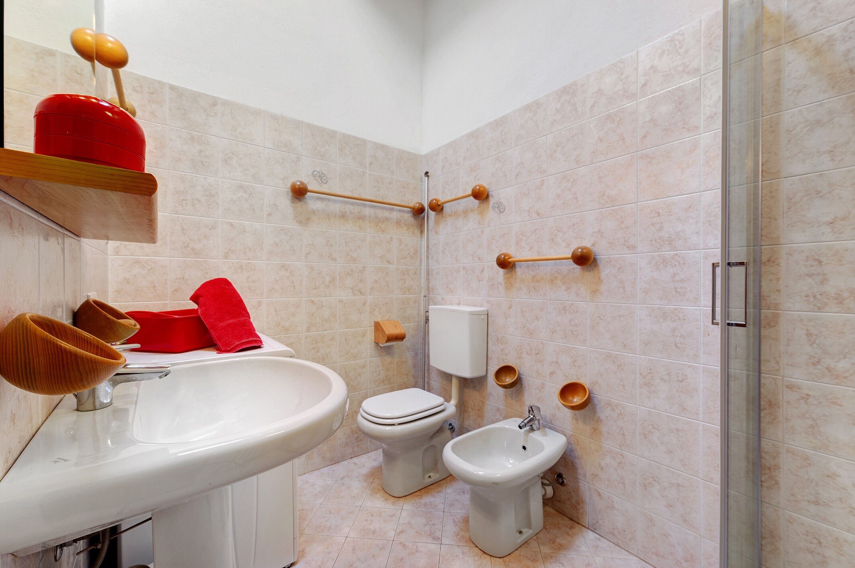 Un baño con lavamanos, inodoro, bidé y zona de ducha.