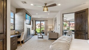 Une chambre d’hôtel moderne dotée d’un grand lit, d’un bureau, d’une chaise, d’un canapé, d’un ventilateur de plafond et offrant une vue sur l’extérieur.