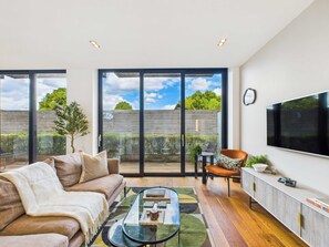 A modern living room with a sofa, coffee table, and a TV.