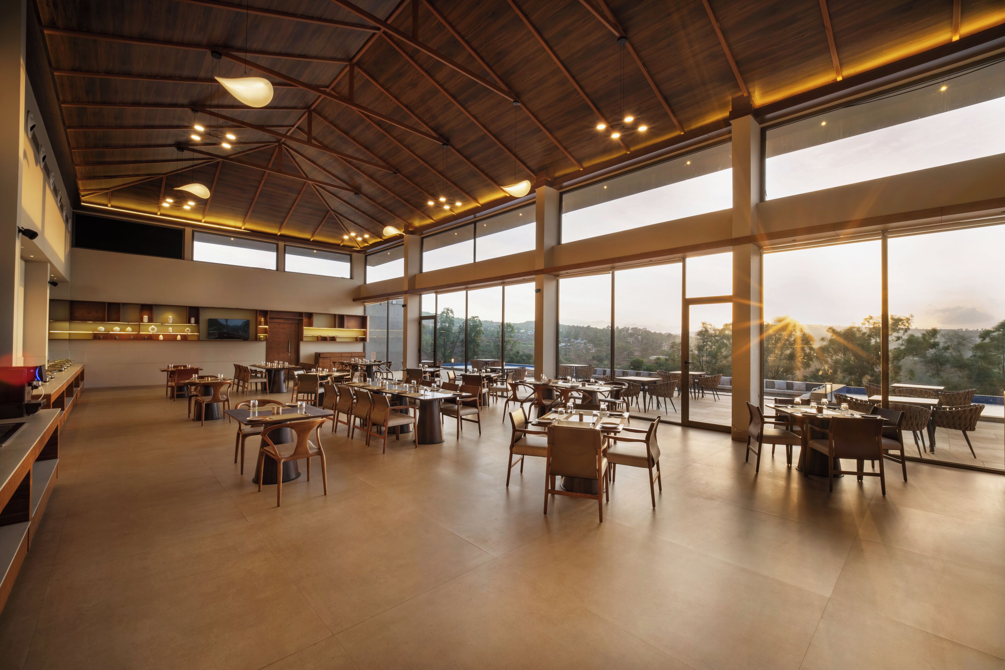 A spacious dining area with high ceilings and large windows offering a view of the outdoors.