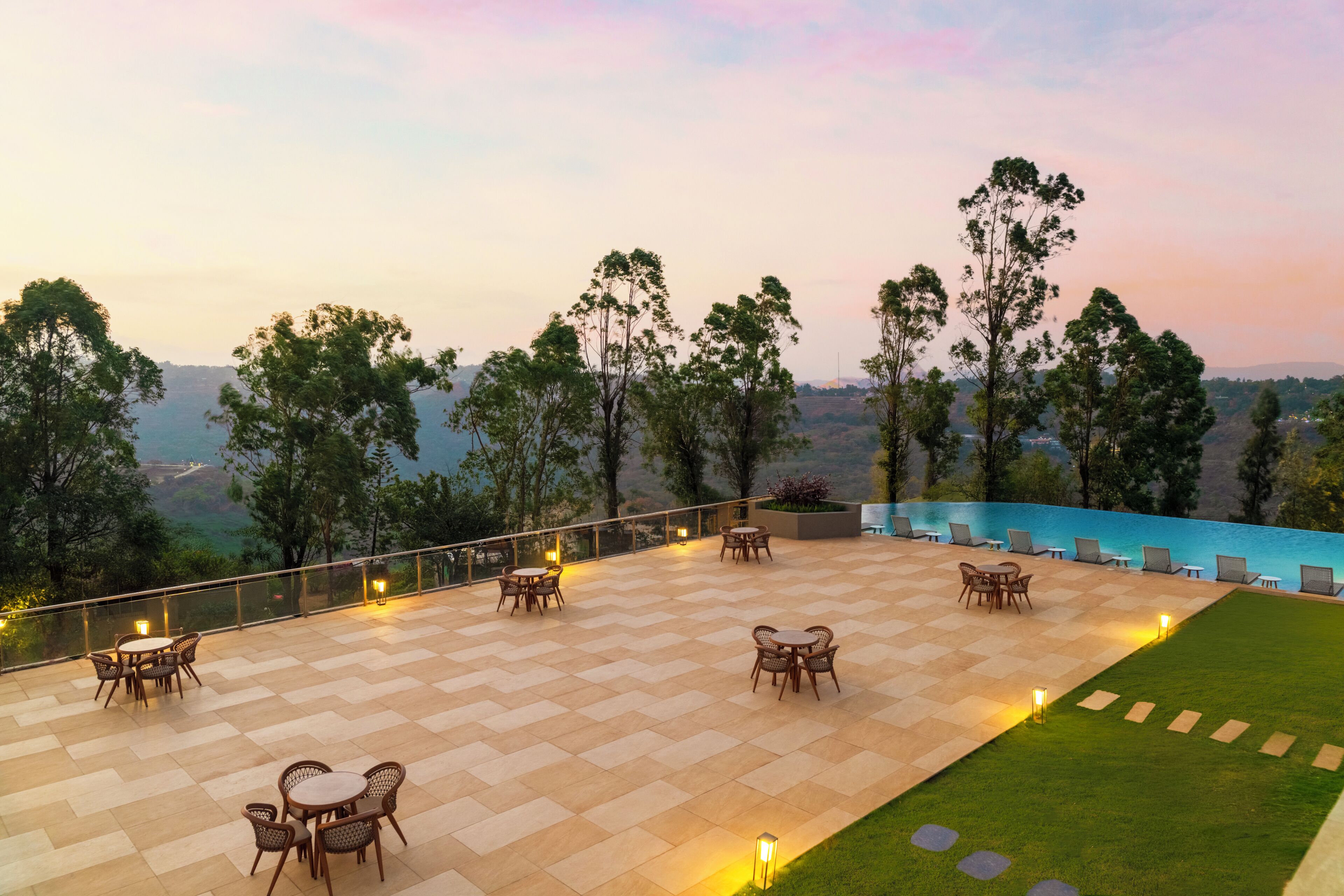 A terrace with outdoor seating, a pool, and a view of the landscape.