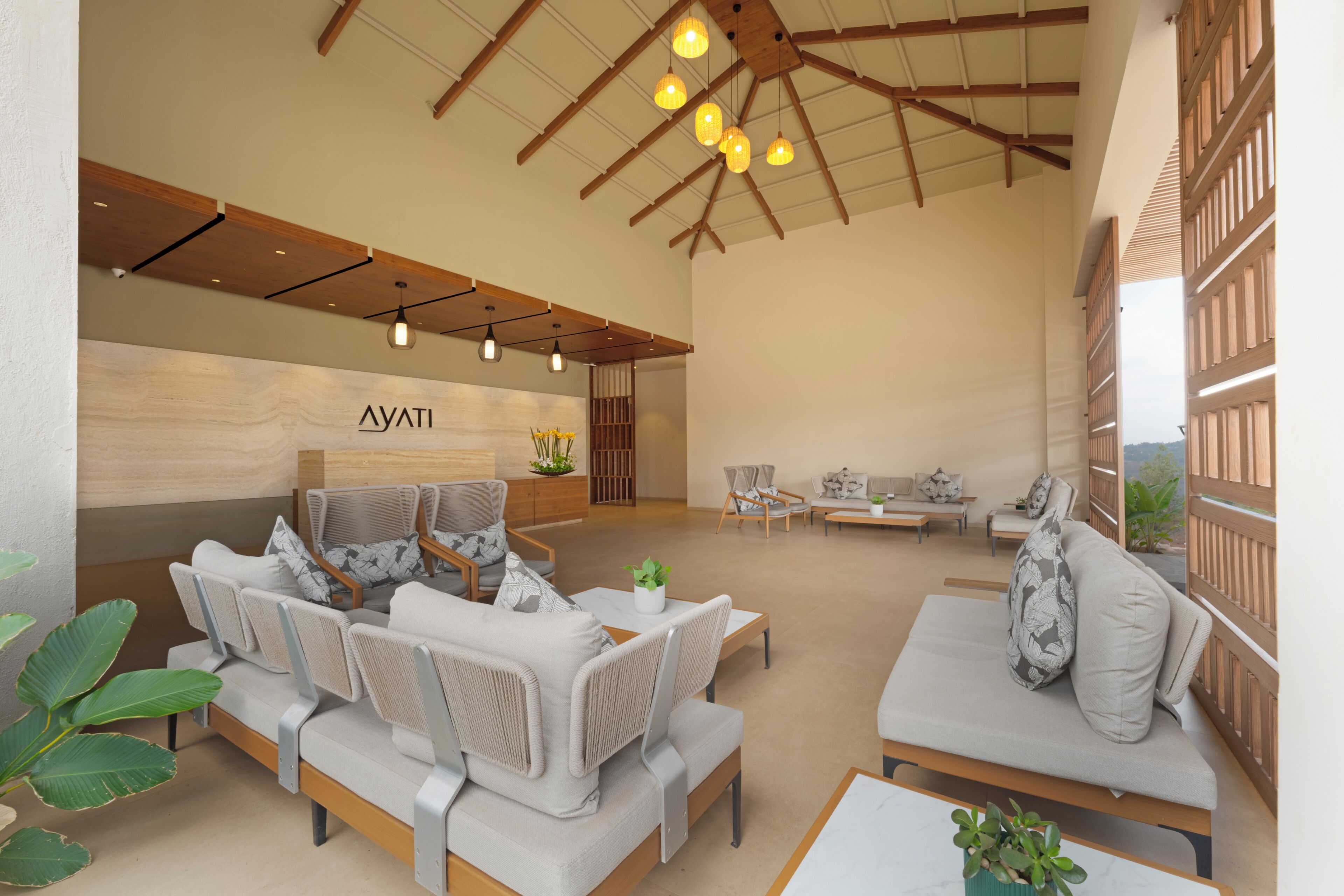 A spacious lobby with a reception desk, seating area, and a view of the outdoors.