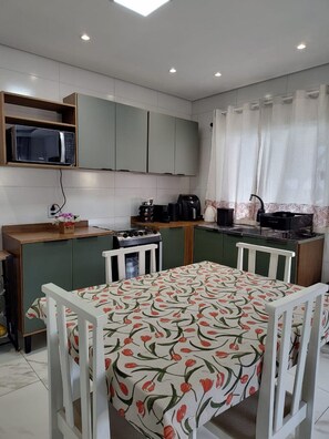 Casa Confort | Cocina privada | Frigorífico, microondas, utensilios de cocina y mesa de comedor