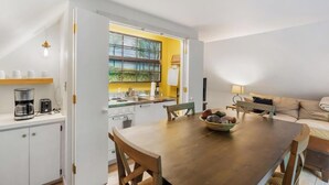 Una cocina compacta con comedor, una ventana con vistas y un sofá en la sala.