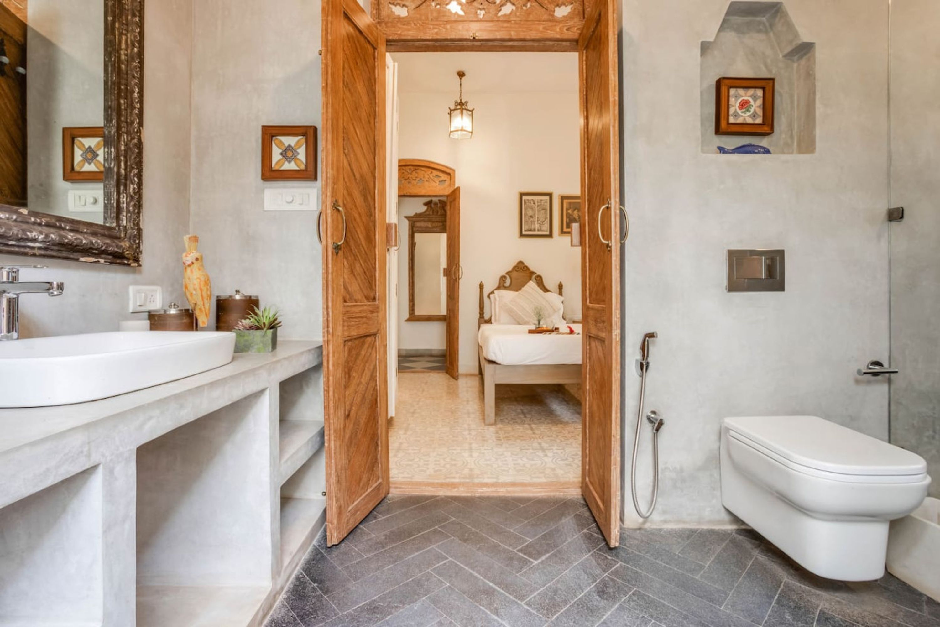 Ein Badezimmer mit Holztür, Waschbecken in Weiß, Toilette und Dusche.